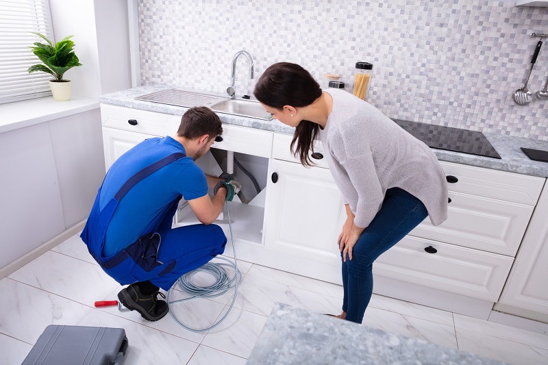 Plumber inspecting kitchen sink