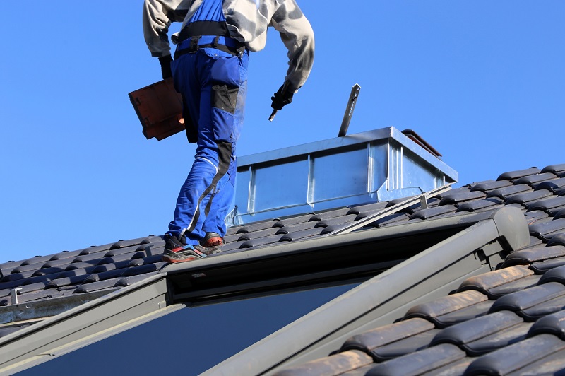 Roofer accessing roof through roof hatch