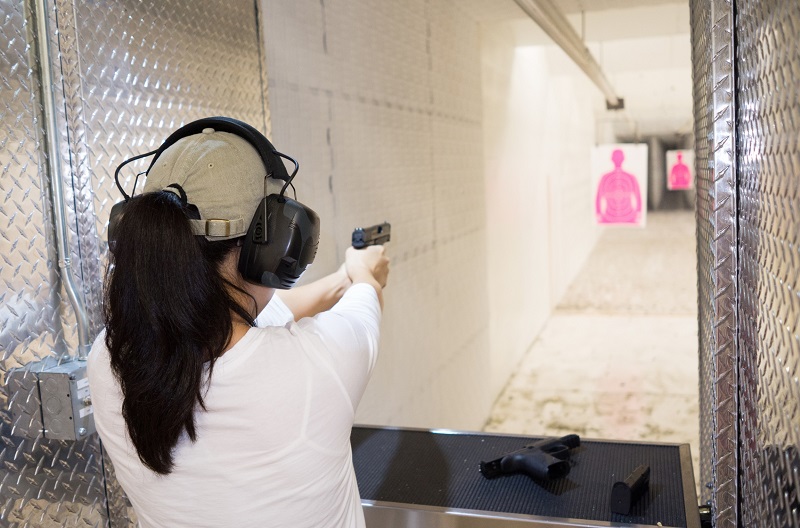 Woman target shooting, comparing two different handguns