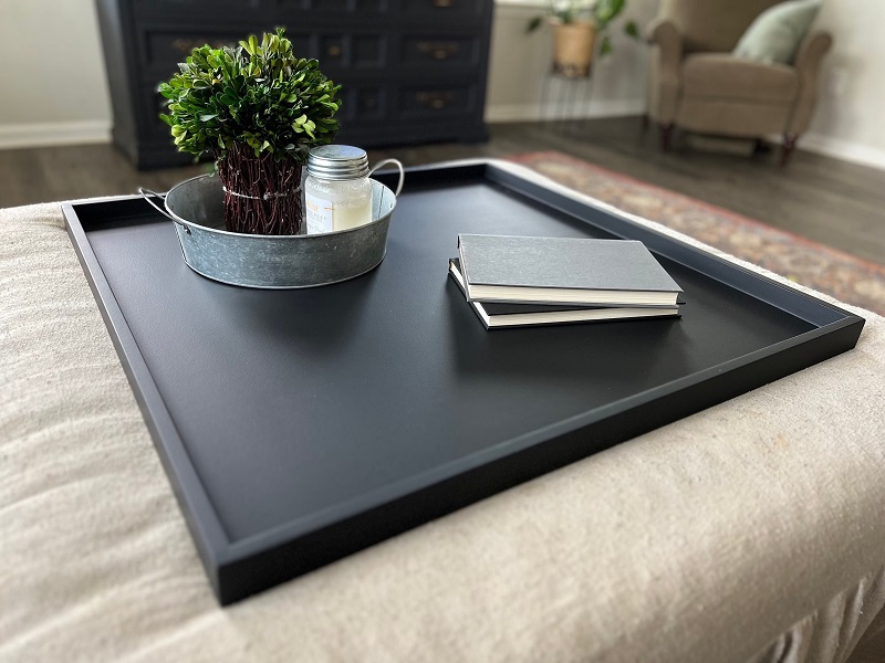 Forever Tray modern and stylish serving tray on top of an ottoman coffee table