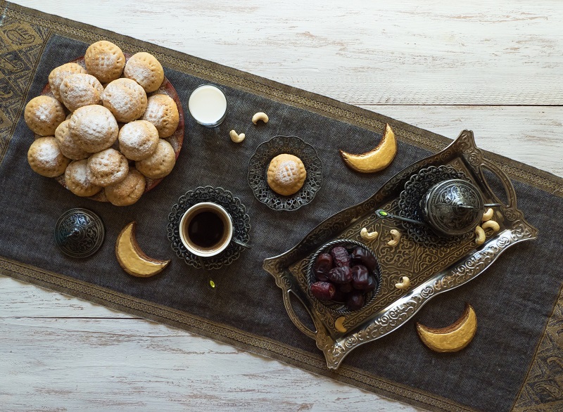 Mediterranean food setting with coffee, cookies, dates on a white-washed wooden coffee table