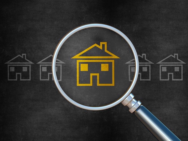 Yellow outline of a house icon under a magnifying lens