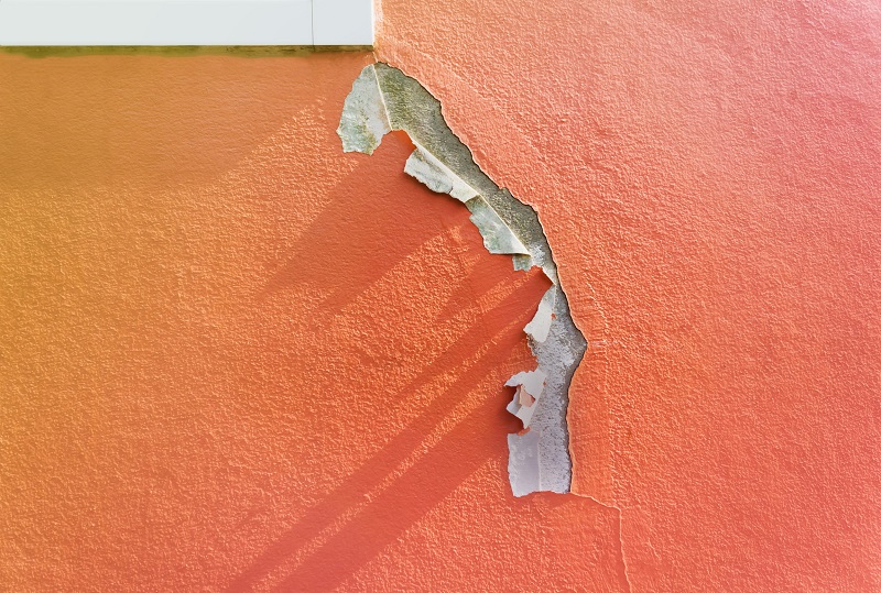 Closeup view of cracked, peeling and faded exterior paint of a house