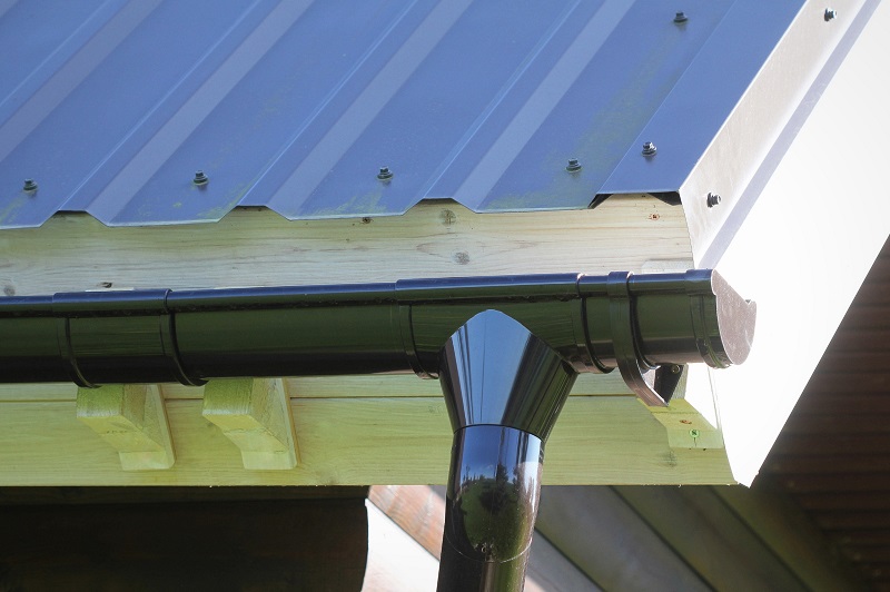 Metal roof with rain gutter system that provides protection against snow
