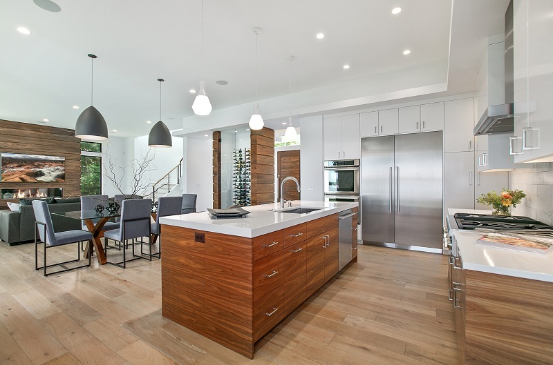 Modern luxury kitchen with wood flooring connecting to the family room