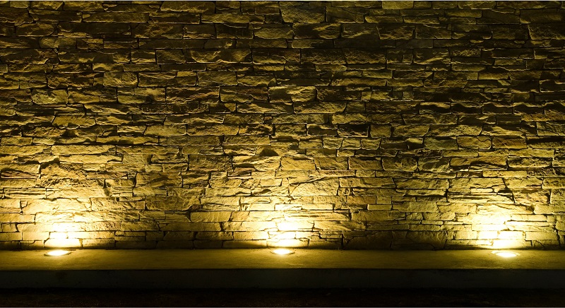 Outdoor up lighting highlighting a brick retaining wall at night