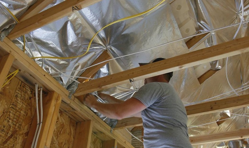 Contractor installing RadiaSource radiant barrier insulation in attic