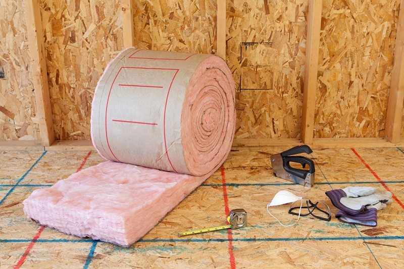 Roll of fiberglass insulation and installation supplies and tools