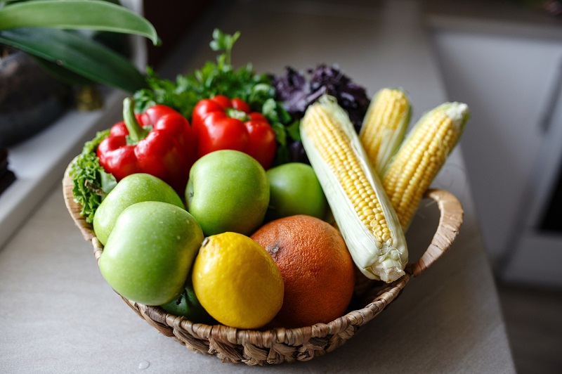 Small basket of fresh fruit and vegetables on kitchen counter