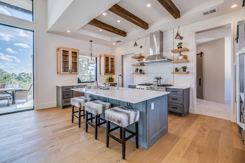 Transitional luxury kitchen with wood flooring connecting to the family room