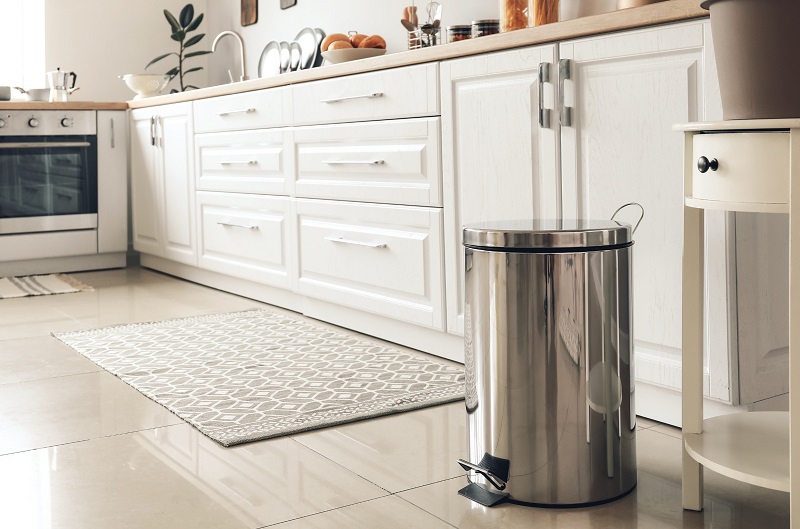 White luxury kitchen with stainless steel waste bin