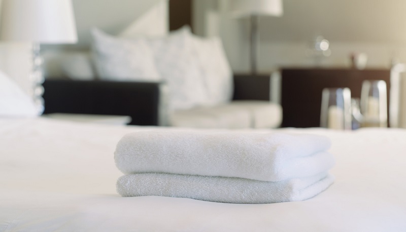 Luxury white towels folded on bed at short-term rental property