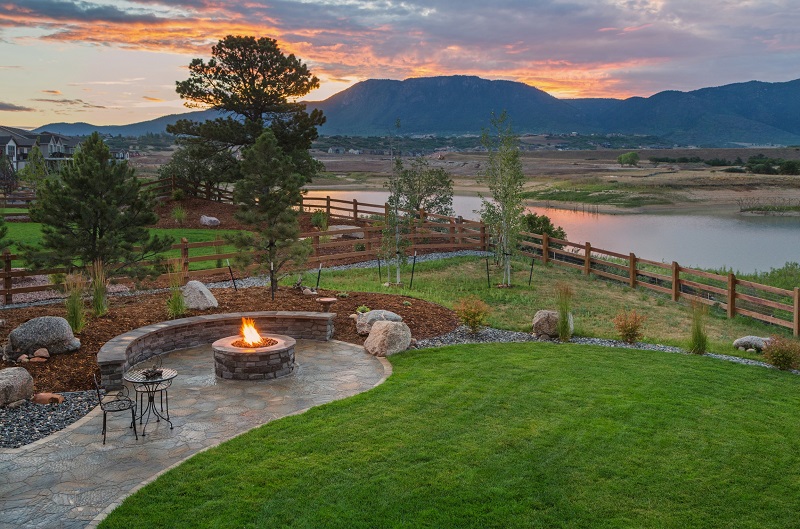Large backyard with fire pit and view of lake and mountains