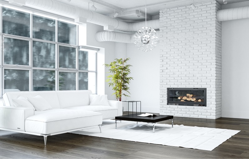 Large loft living room with white painted fireplace brick and hardwood flooring