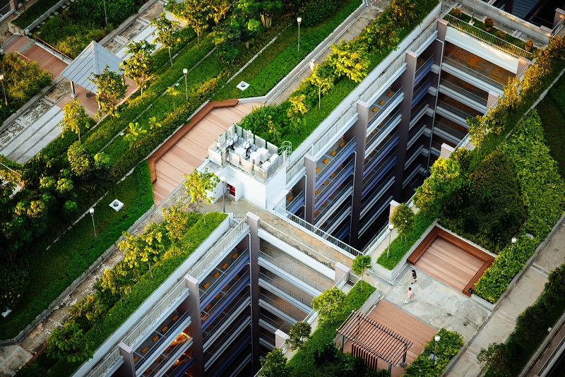 Green condominium building with lush rooftop. Photo by Chuttersnap on Unsplash