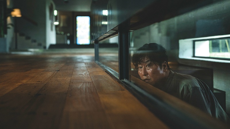 Scene from the Oscar winning Korean film Parasite, father Ti Taek peering out from a stairway