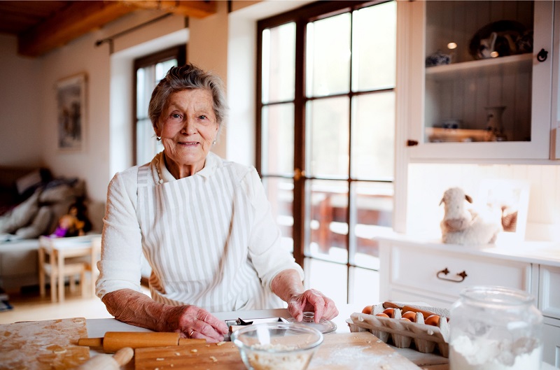 Smiling elderly grandmother baking in kitchen