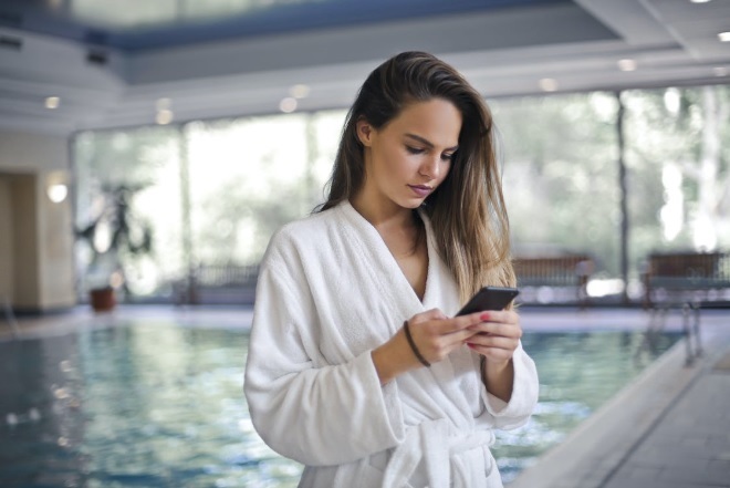 Young woman accessing mobile swimming pool monitoring app