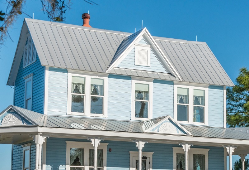 Light blue Victorian home with new gray metal roof