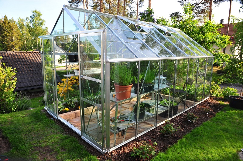 Backyard greenhouse with silver frame and movable panels
