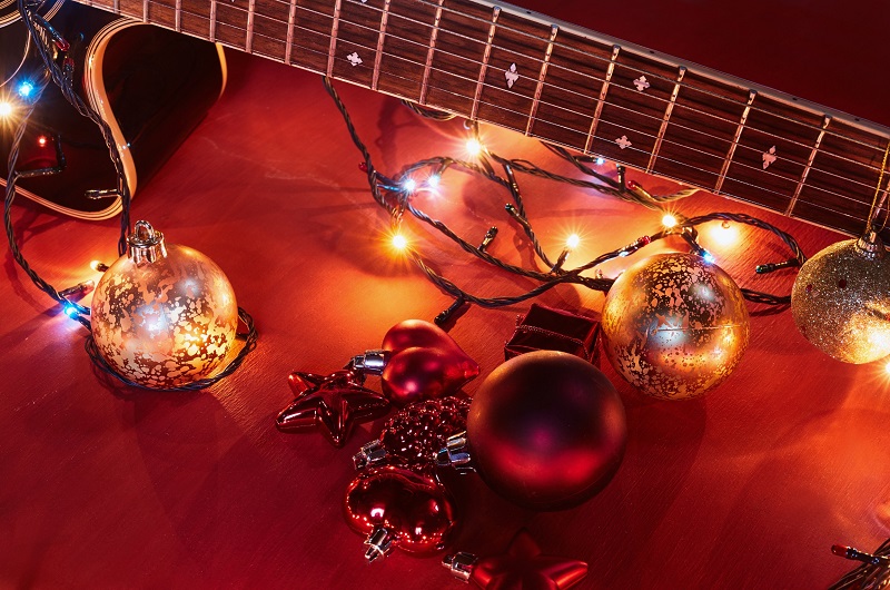 Electric guitar draped with Christmas lighting and decorations