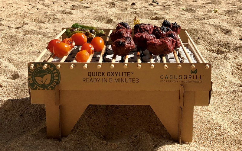 CasusGrill single-use biodegradable bamboo grill in use at the beach