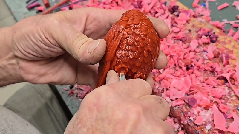 HF Home Jewels artisan carving a wax peacock