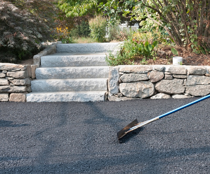 Smoothing new asphalt surface with lute