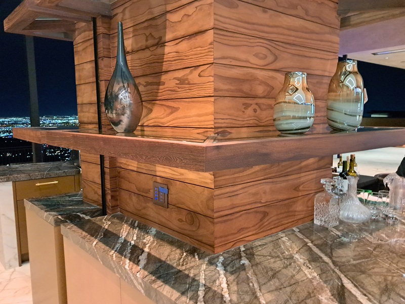 Wood and stone materials that extend from the indoor kitchen to the outdoor kitchen and wet bar