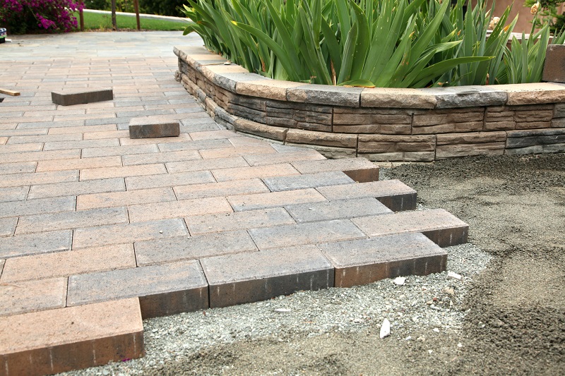 Brick pavers being installed in a large backyard garden