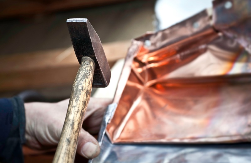 Craftsman working with copper sheets