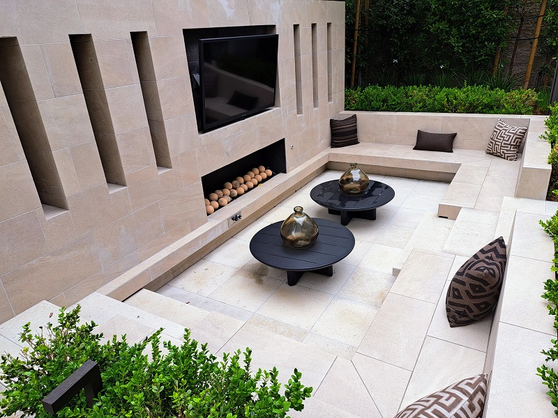 Beautifully hardscaped backyard patio with permanent seating