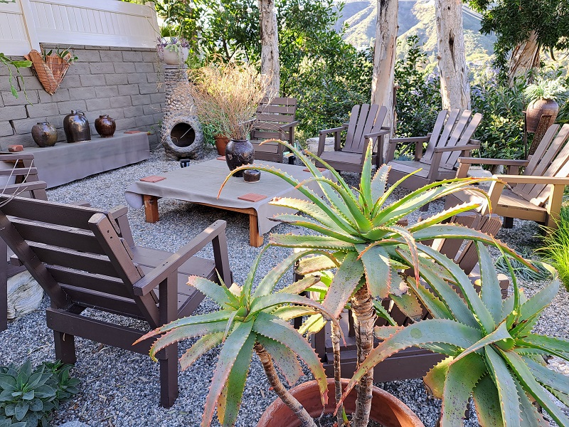 Outdoor seating area with native plants and pottery with a peaceful view