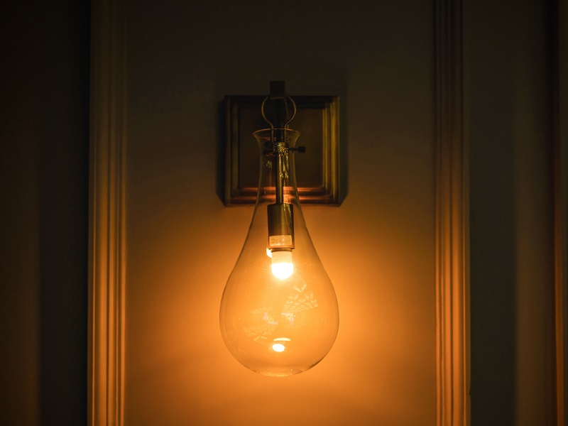 Retro copper wall sconce in dimly lit hallway