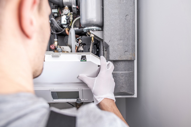 HVAC technician inspecting a central heating furnace system