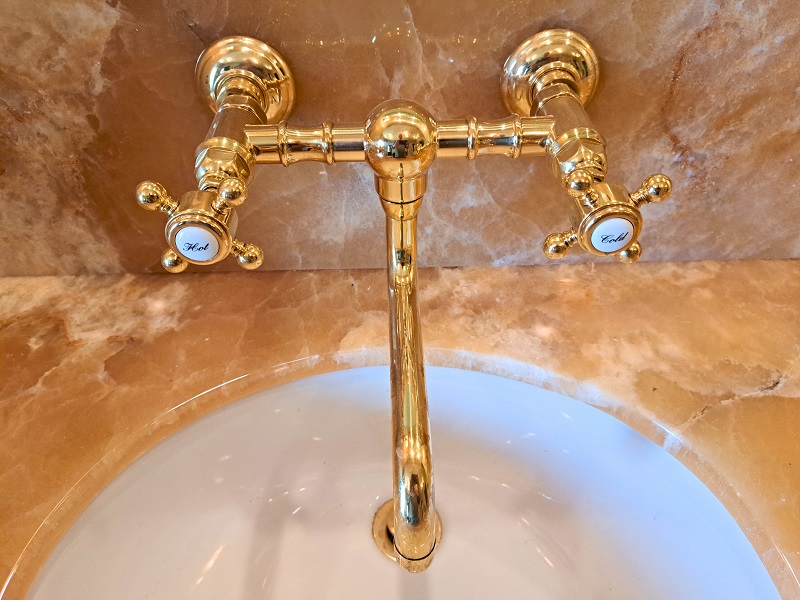 Bright shiny brass bathroom faucet in the master suite bathroom in the 2025 Pasadena Showcase House