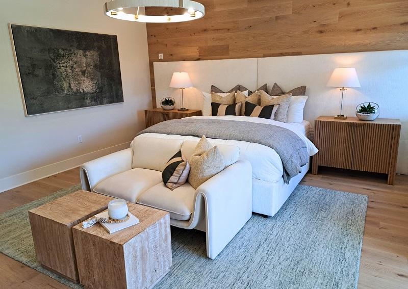 A cozy bedroom retreat with neutral colors and warm wooden treatments