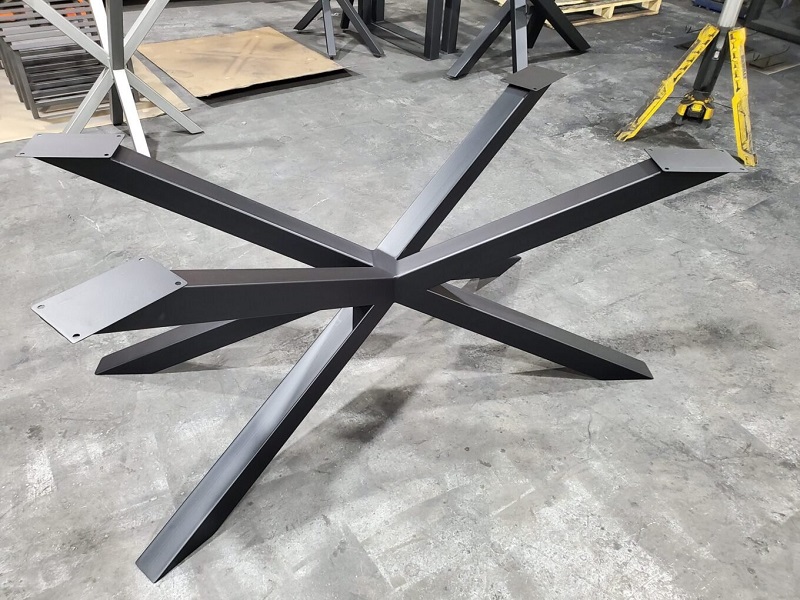 A custom black steel table base with cross bars
