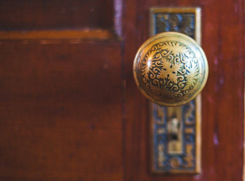 Ornate vintage door knob on dark wooden interior door
