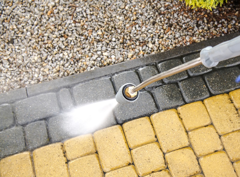 Professional power washing of a paver driveway