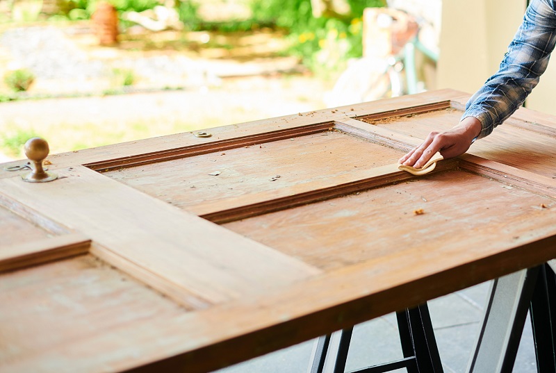 Sanding an old wooden door as part of a restoration project