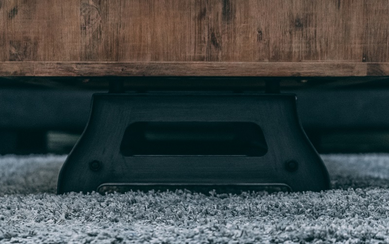 A wooden coffee table with a black steel base
