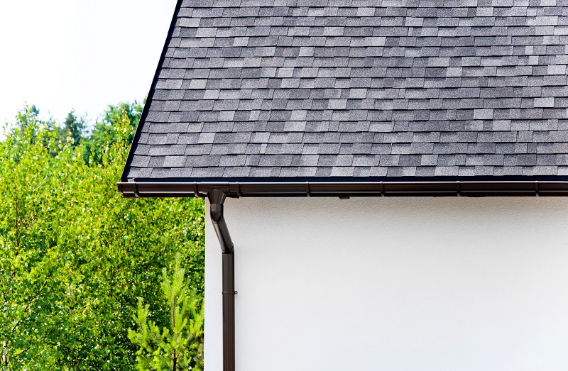 Home with a well-maintained rain gutter and downspout