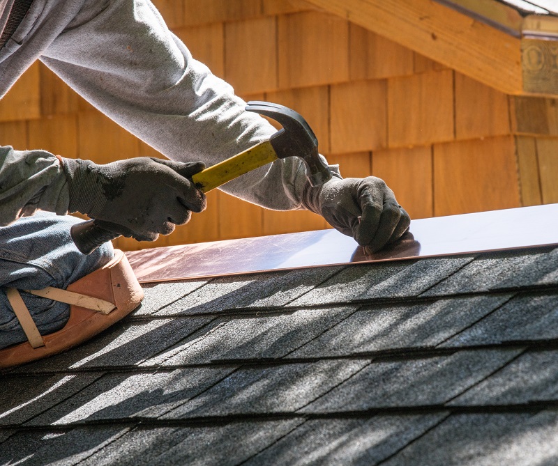 Contractor installing copper flashing on a home's roof