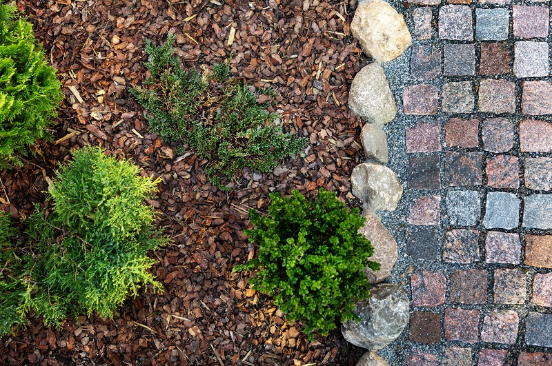 Aerial view of fresh mulch and hedges next to a stone pathway