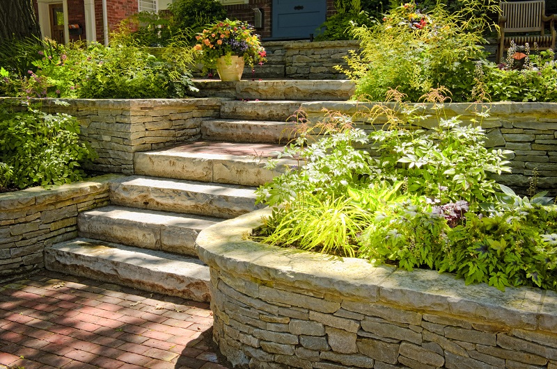 Home with plants and natural stone hardscaping leading to the front entrance