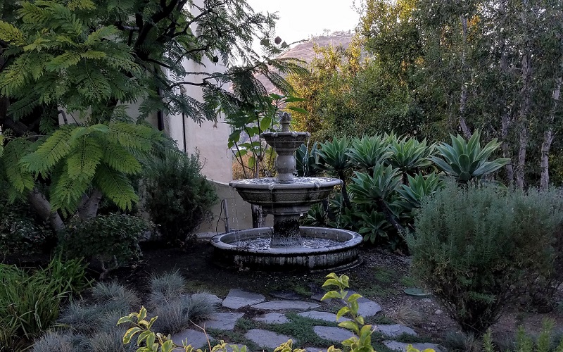 Outdoor fountain surrounded by lush native landscaping