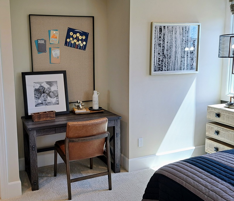 Small desk in a teen bedroom with large corkboard