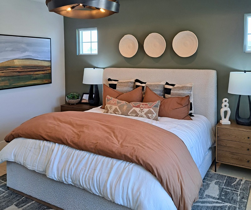 Bedroom with green accent wall that matches color palette of the space