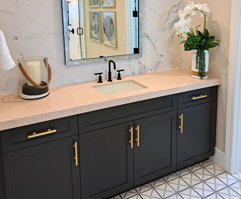 Gold bathroom hardware against a dark blue vanity